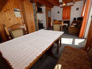 Relax in this rustic-style room with a dining table, sofa, and TV.