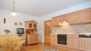 Eine kleine Küche mit Holzausstattung, einem Backofen und einem Geschirrspüler.