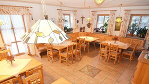 Ein gemütlicher Essbereich mit Holzmöbeln und einer großen Zierleuchte.