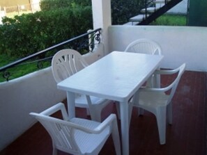 A balcony with a white table and four white chairs. - Simplistic Apartment in Rosolina Mare near Sea (Rosolina)