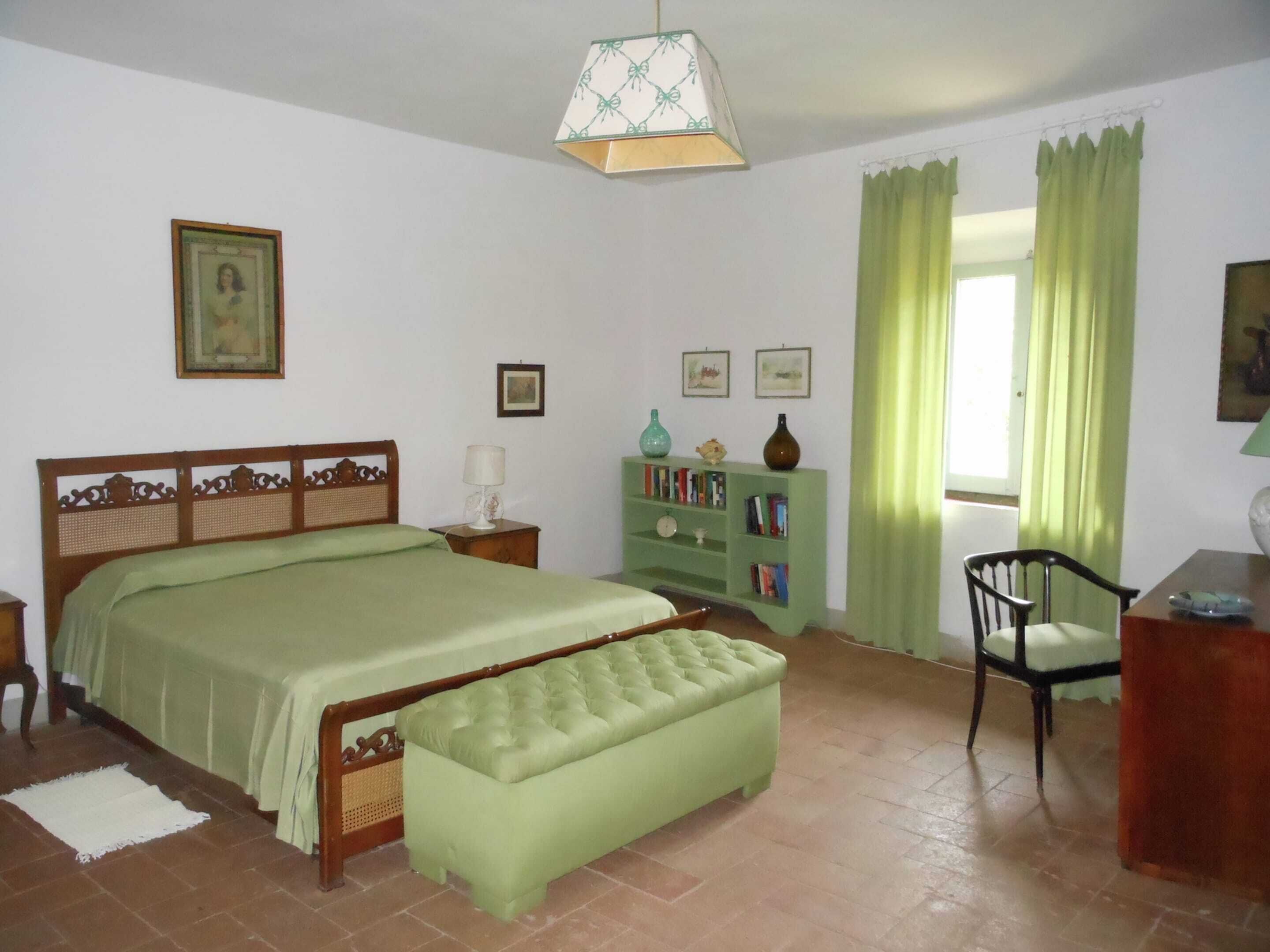 A bedroom with a bed, a bench, a nightstand, a dresser, and a chair.