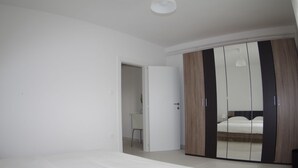 A bedroom with a bed, a wardrobe, and a door leading to another room. - Apartment in Krnica Near Pula Airport (Marcana)
