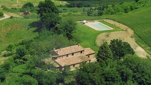 An aerial view of a rustic house surrounded by lush greenery, with a swimming pool and a dirt path leading to it. - Farmhouse in Proceno With Pool Views (Proceno)