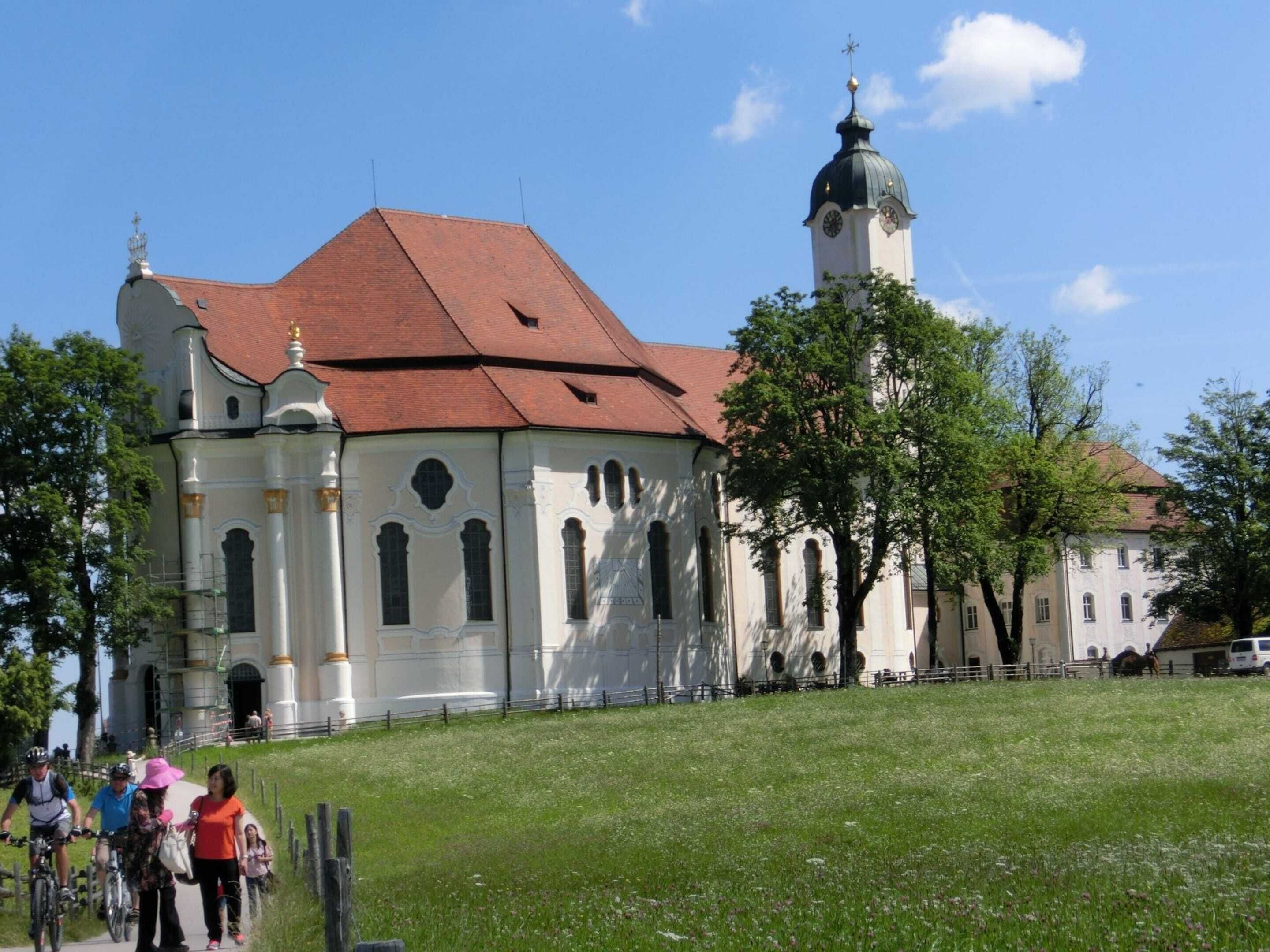 A historic church with a red-tiled roof and a bell tower.