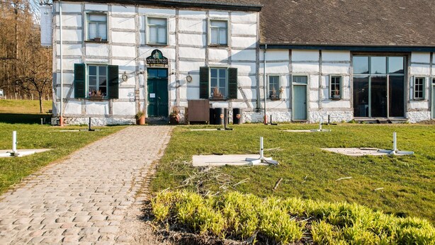 A traditional half-timbered building with a cobblestone path leading to the entrance.