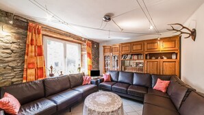 A living room with a stone wall, wooden cabinets, a leather sofa, and a round table.