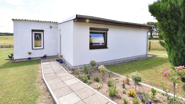 A modern two-story house with a paved pathway leading to the entrance, surrounded by a well-maintained garden with various plants and flowers. - Modern Bungalow in Damshagen in Terrace, Garden and Barbecue (Damshagen)