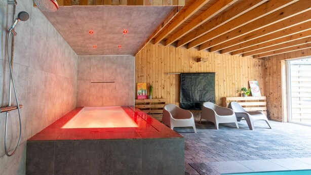 A modern spa area with a heated floor, wooden walls, and a pool. - Mansion With Pool & Bar (Buellingen)