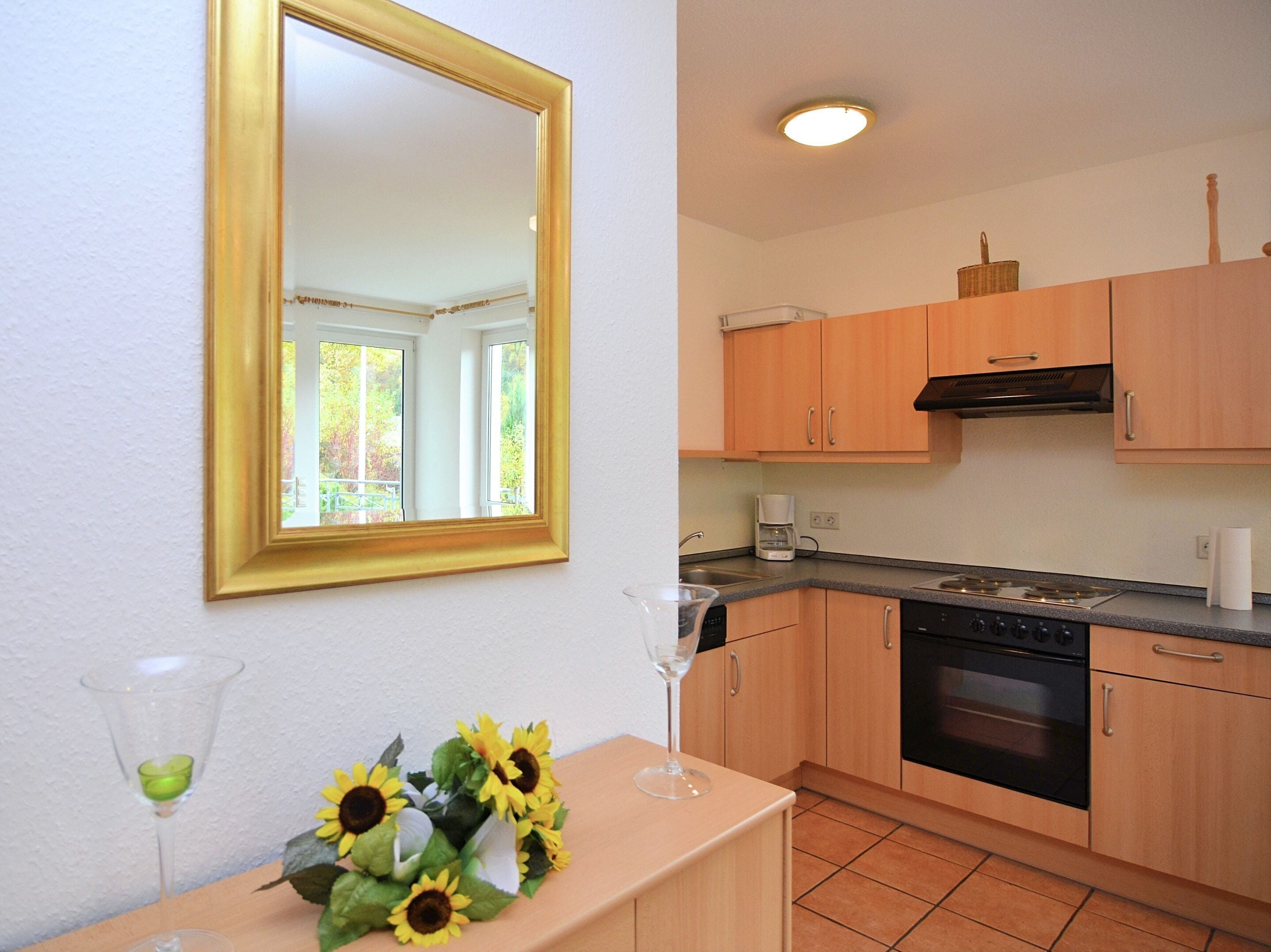 A kitchen with wooden cabinets, a stove, and a dishwasher.