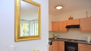 A kitchen with wooden cabinets, a stove, and a dishwasher. - Wohnung in der Nahe der Hessischen Berge (Willingen)