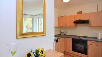 A kitchen with wooden cabinets, a stove, and a dishwasher.