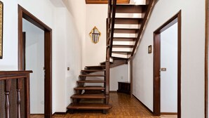 Un escalier en bois, doté d’une rampe, menant à l’étage supérieur.