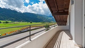 Un balcon donnant sur une route et des montagnes.