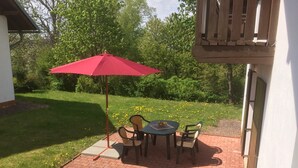 A patio with a red umbrella, brick flooring, and a table with chairs. - Holiday Home With a Convenient Location in the Giant Mountains for Summer & Winter (Rudník)