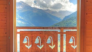 A wooden cabin with a large window displaying a mountain landscape. - Chalet in Les Collons Near Ski Lift (Vex)
