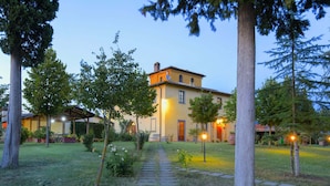 A pathway leading to a building with a yellow facade and multiple windows. - Belvilla by OYO Villa Santa Caterina (Cortona)