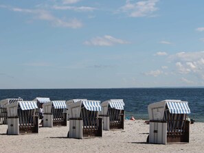 Beach huts with striped awnings, arranged in rows on a sandy beach, overlooking the sea. - Idyllische Wohnung an der Ostseekueste (Damshagen)