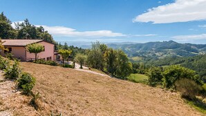 Una casa con vista su una valle e montagne.