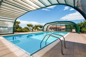 A clear swimming pool with a glass enclosure, surrounded by lounge chairs and a tiled deck. - Farmhouse in Apecchio With Pool (Apecchio)