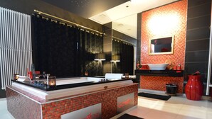 Ein modernes Badezimmer mit einer zentralen Insellösung, einem Waschbecken und einem Spiegel.