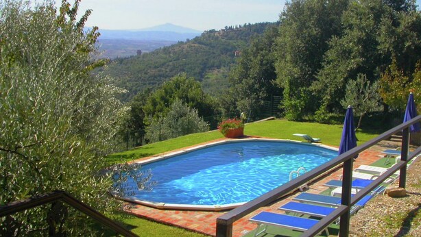 A swimming pool with a view of a mountainous landscape, surrounded by greenery and a clear sky. - Belvilla by OYO Leccio Lauro Quattro (Cortona)