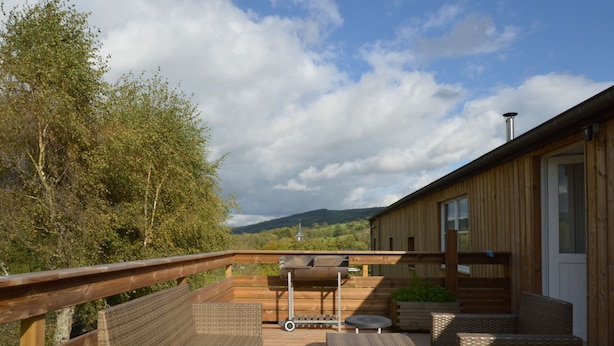 A wooden deck with wicker furniture, a barbecue grill, and a scenic view of hills and trees. - Countryside Holiday Home in Stoumont With Terrace, Garden (Stoumont)