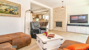 Een woonkamer met een bank, een salontafel, een televisie en een open haard.