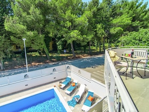 A pool area with lounge chairs and a table, surrounded by trees. - Modern Villa with Private Pool & Hot Tub near Center & Beach (Novigrad)