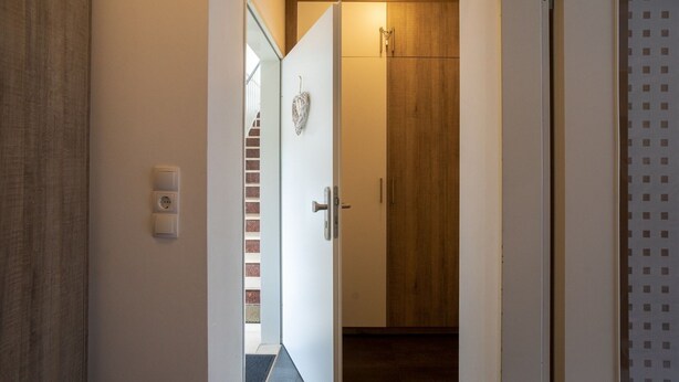 A hallway leading to a room with a wooden door and a small window. - Cozy Apartment in Willingen near Willingen Train Station (Willingen)
