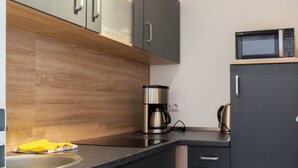 A modern kitchen with a built-in microwave, coffee maker, and a sink. - Cozy Apartment in Willingen near Willingen Train Station (Willingen)