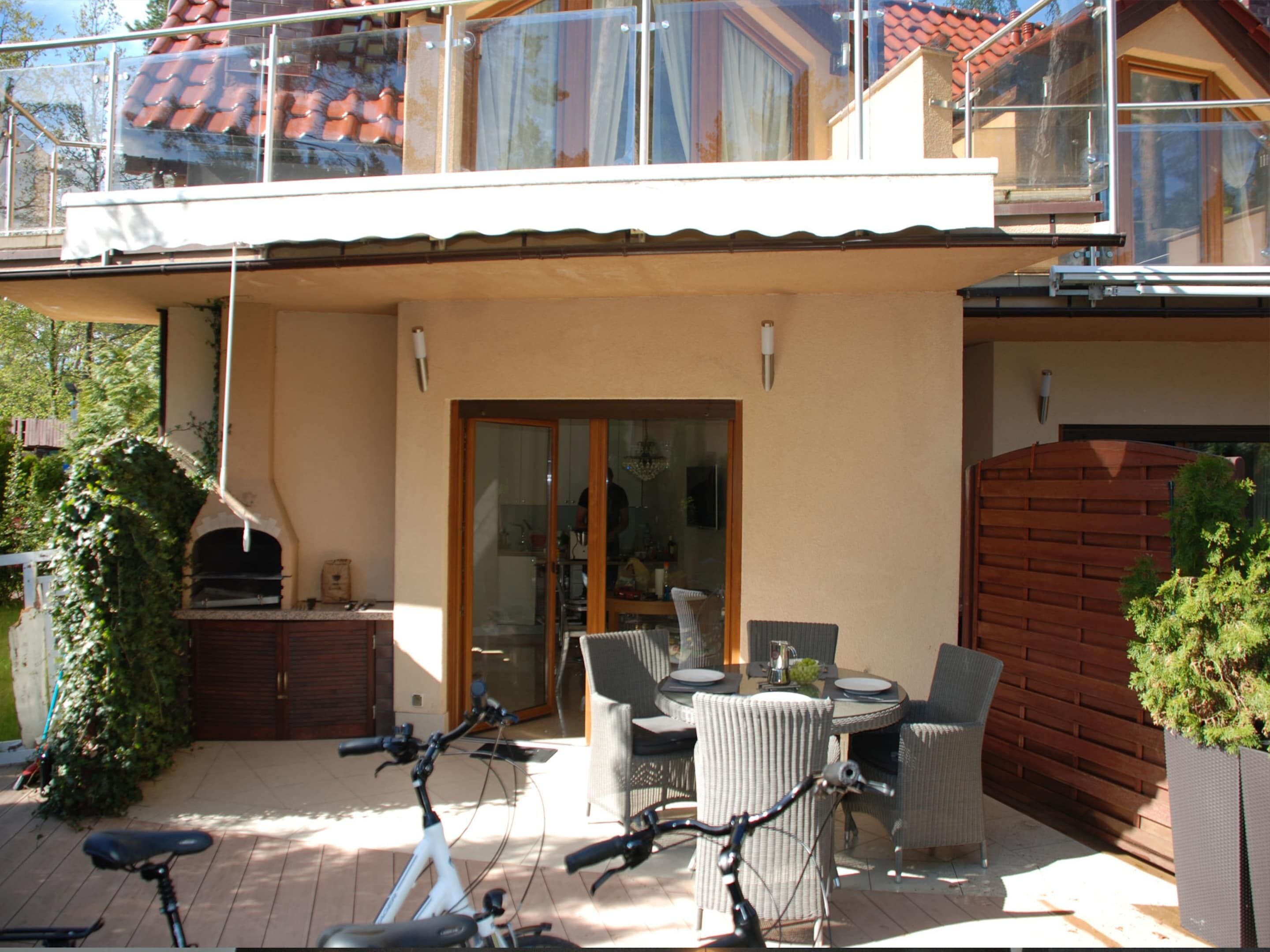 A patio with outdoor furniture, a bicycle, and a wooden fence.
