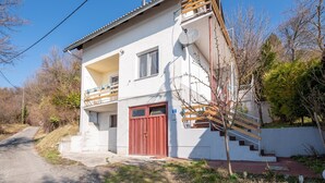 A two-story house with a red door, a balcony, and a satellite dish. - Holiday Home in Prilipje With Terrace (Jastrebarsko)