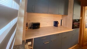 A kitchen with light wood cabinets, a countertop, and a coffee maker. - Holiday Home With Terrace in Graal-muritz (Graal Mueritz)