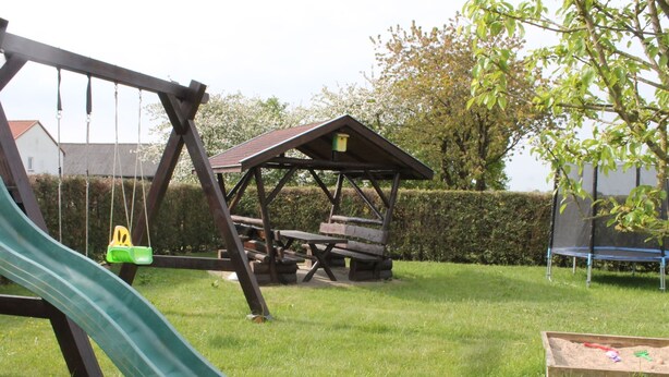 A playground with a slide, swings, and a picnic table. - Rustic Escape in Kropelin (Kroepelin)