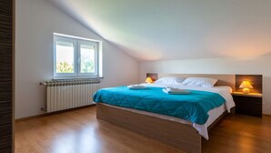 A bedroom with a bed, two bedside lamps, a window, and a radiator. - Spacious Apartment in The Croatian Islands (Malinska-Dubasnica)