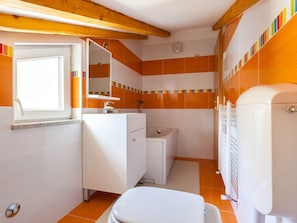 Ein kleines Badezimmer mit Toilette, Waschbecken und Spiegel.