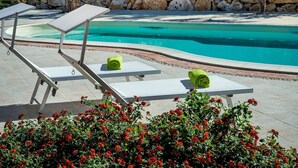 A poolside area with lounge chairs and a stone wall. - Rustic Villa With Pool, Sicily (Castellammare del Golfo)