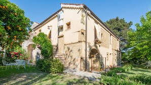 A rustic stone building with a garden, outdoor seating, and a staircase leading to the entrance. - Holiday Home in Guardavalle by River (Stilo)