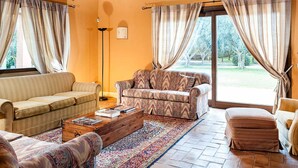 A living room with a sofa, armchair, and ottoman, a wooden coffee table, and a patterned rug. - Belvilla by OYO Villa Arangea Dieci (Marsala)