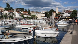 A marina with various boats docked, surrounded by buildings and a clear sky. - Nice Apartment With Terrace Near the Beach (Malinska-Dubasnica)