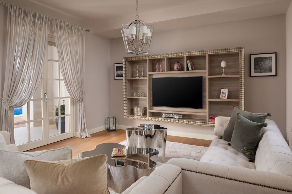 A living room with a sofa, a coffee table, a TV, and a bookshelf.