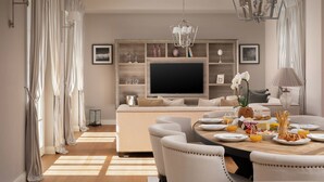 A dining area with a round table set for four, a sofa, and a television in the background. - Villa in Vabriga With Private Pool & Garden (Tar-Vabriga)
