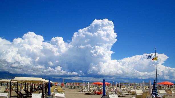 A beach with rows of sun loungers and umbrellas under a clear sky. - Lucca Retreat With Pool (Lucca)