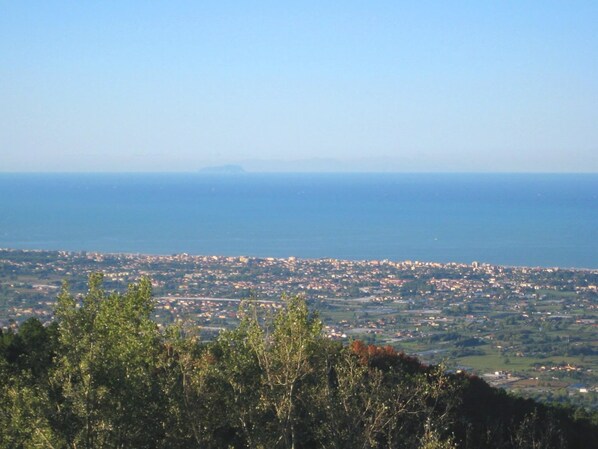 Un paisaje urbano costero con vista al mar y montañas distantes.