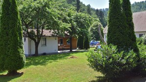 Ein Wohngebiet mit einem Haus, einem Rasen und einem Auto auf der Einfahrt.