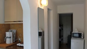 A compact kitchen with a coffee maker, microwave, and toaster on the counter. - Apartment in Kroepelin Near Baltic Sea (Kroepelin)