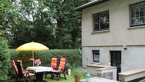 A patio with a table and chairs, a yellow umbrella, and a potted plant. - Apartment in Kroepelin Near Baltic Sea (Kroepelin)