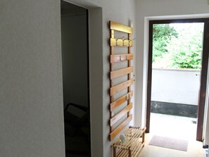 A hallway with a wooden rack holding keys and a small shelf with a glass object. - Apartment in Kroepelin Near Baltic Sea (Kroepelin)