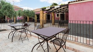 An outdoor patio area with a table and chairs, a pergola, and a fenced garden. - Holiday Home Near Mount Etna Views (Carlentini)