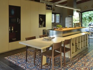 Una cucina moderna con isola centrale, elettrodomestici integrati e pavimento decorato.